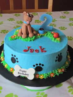 a birthday cake with a dog on top and the number 2 in front of it