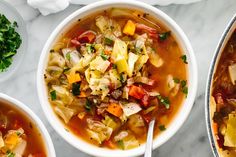 three bowls of vegetable soup on a marble table