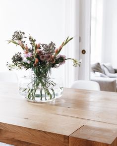 a vase filled with flowers sitting on top of a wooden table