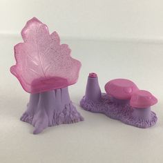 two plastic toys sitting next to each other on a white surface