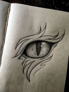 a drawing of an eye with flames coming out of the iris's eyes, on top of a piece of paper