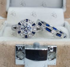 two diamond and blue sapphire engagement rings in a box