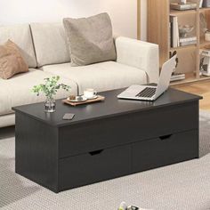 a living room with a couch, coffee table and laptop on top of the table