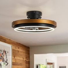 a living room with wood paneling and a round light fixture hanging from the ceiling