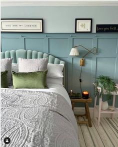 a bedroom with blue walls and white bedding