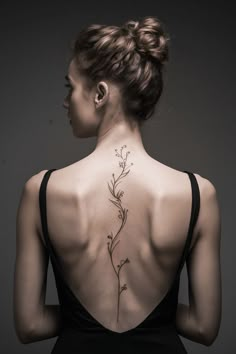 the back of a woman's neck with flowers on it