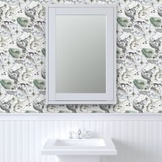 a white sink sitting under a bathroom mirror next to a wall mounted faucet