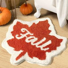 a red and white rug with the word canada on it next to some pumpkins