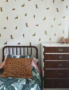 a bed room with a neatly made bed and wallpaper