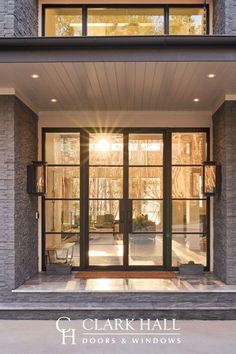 the front entrance to a house with glass doors and windows