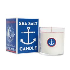 a candle that is next to a box with an anchor on the front and sea salt in it