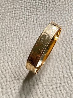 Made in 1962 - Wide Hinged Bangle in 18k gold - Etched Curls Pattern - Stockholm, Sweden - Size 7 Stunning vintage hinged bangle crafted in 18k yellow gold. Bangle was made in 1962 by maker GFP active 1945-1968. Bracelet has full Swedish hallmarks for maker, year, location and gold purity.  By hand, the goldsmith etched a wonderful swirling curl pattern on one side of the bangle and polished the other side - you can wear her either way - a two in one! She is oval shaped measuring 7 inches inside Elegant Hallmarked Bangle For Formal Events, Luxury Yellow Gold Ceremonial Bracelets, Elegant Ceremonial Bangle With Polished Finish, Luxury Collectible Round Bangle, Yellow Gold Jewelry With Gold Clasp For Evening, Evening Yellow Gold Jewelry With Gold Clasp, Hallmarked Yellow Gold Bracelet For Ceremonial Occasions, Classic 22k Yellow Gold Bracelets, Antique Polished Bracelets For Formal Occasions