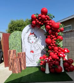 an outdoor display with red balloons and artwork