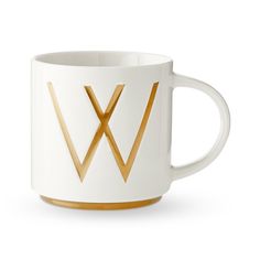 a white and gold coffee mug with the letter w on it's front side