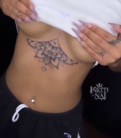 a woman with tattoos on her stomach holding onto a white pillow and looking at the camera