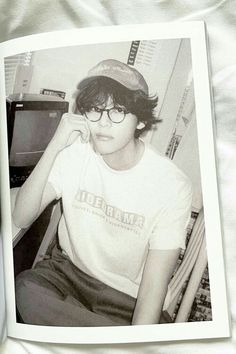 an old photo of a young man wearing glasses and a hat