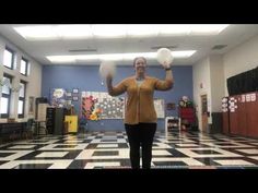 an older woman juggling with two balls in her hands while standing on a black and white checkered floor