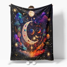 a tapestry hanging on the wall with an image of a crescent, stars and planets