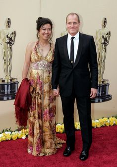 a man and woman in formal wear standing next to each other on a red carpet