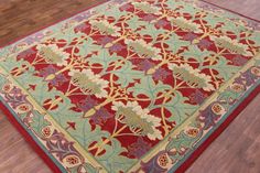 a red and blue area rug with flowers on the center is laying on a hard wood floor