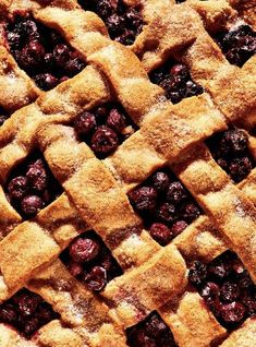 a close up view of a pie with blueberries in it's lattice crust