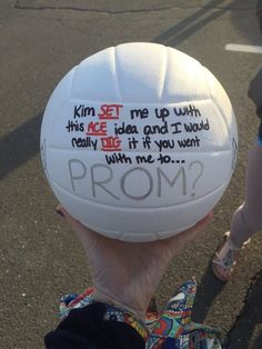 a person holding up a white ball with writing on it