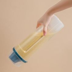 a person is holding a plastic cup with something in it and reaching for the lid