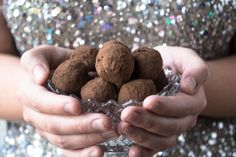 a woman holding some chocolate balls in her hands