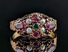 This stunning Victorian era ring is a real beauty.  Full of old Victorian charm, it is crafted in rich 15ct gold with a plethora of gems set to the face including Garnet, Pearl and Green paste, set in a pretty flower design, possibly a nod to the popular forget me not flower pieces.  It has an elaborate setting and beautifully engraved shoulders and band.  A true gem of an antique ring this is also a great style for stacking with other rings.  Marks and era: Victorian era, marked for 15ct gold, Antique Oval Multi-stone Ring, Victorian Gold Cluster Ring With Gemstone, Victorian Multi-stone Yellow Gold Diamond Ring, Antique Multi-stone Yellow Gold Cluster Ring, Antique Multi-stone Cluster Ring In Yellow Gold, Victorian Multi-stone Cluster Ring, Victorian Cluster Ring With Multi-stone, Antique Gold Cluster Ring With Multi-stone, Antique Multi-stone Cluster Ring