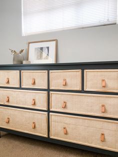 a dresser with drawers and pictures on top