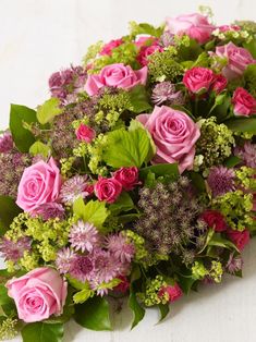 a bouquet of pink roses and green leaves