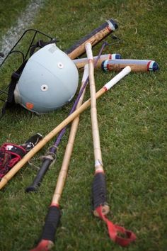 several baseball bats and helmets on the ground