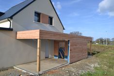 a house being built on the side of a road with a blue door and windows