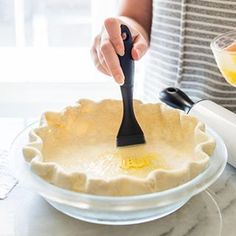 a person with a brush on top of a pie