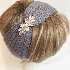 a woman's head wearing a gray knitted beanie with crystal brooch