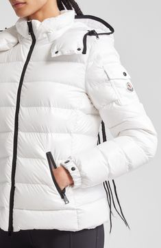 Whether you're headed somewhere metropolitan or mountainous, you'll stay warm in this sporty down puffer made from Moncler's water-resistant lacquered nylon. Elasticized cuffs and a detachable drawcord hood provide extra protection from the elements. Two-way front-zip closure Stand collar; removable drawcord hood Elastic cuffs with adjustable snap tab Front zip pockets; sleeve snap-flap pocket Lined, with down fill 100% polyamide Dry clean or machine wash, line dry Imported Designer Clothing Winter White Outdoor Puffer Jacket With Padded Collar, Winter White Puffer Jacket With Padded Collar For Outdoor, White Quilted Puffer Jacket For Cold Weather, White Duck Down Puffer Jacket With Padded Collar, White Nylon Puffer Jacket With Detachable Hood, White Quilted Down Outerwear, White Down Outerwear With Padded Collar, White Duck Down Outerwear For Outdoor, Luxury Nylon Puffer Jacket