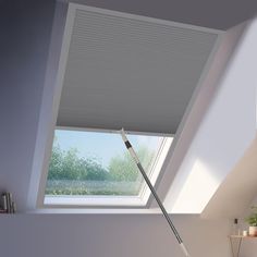 a room with a skylight and a broom in the corner on the floor next to it