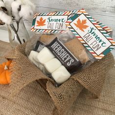 a basket filled with marshmallows, cookies and other treats sitting on top of a burlap bag