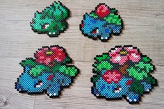 four pieces of pixel art on a wooden surface