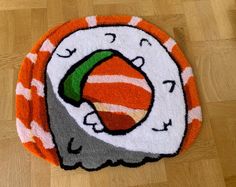 an orange and white rug with a sushi on the front is laying on a wooden floor