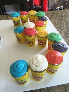 there are many cupcakes on the table with frosting in each and different colors