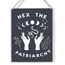 a sign that says hex the patriachy with two hands holding an object