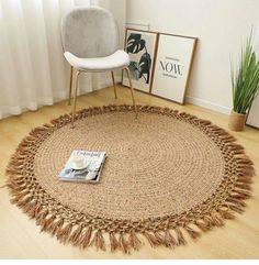 a round rug with tassels on the floor next to a chair and potted plant