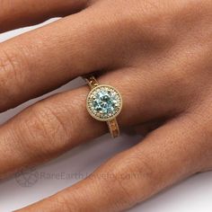 a woman's hand with a ring on it and a blue stone in the middle