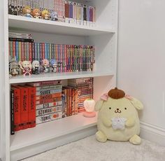 a stuffed animal sitting in front of a book shelf filled with books