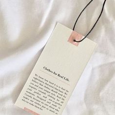 a bookmark is laying on a white sheet with a black string attached to it