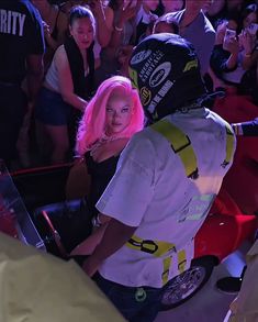 a woman with pink hair standing next to a man