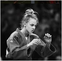 a woman in a black and white photo holding her hands together while wearing a kimono