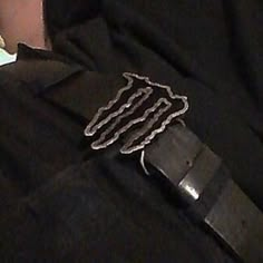 a close up of a person wearing a black shirt with chains attached to the belt