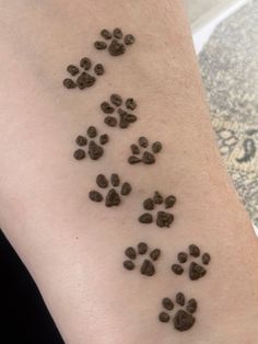 a person with a tattoo on their arm that has dog paw prints